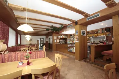 a restaurant with a wooden table and chairs at Hotel Alpino Plan in Selva di Val Gardena