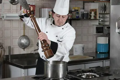 a chef is stirring a pot in a kitchen at Hotel Alpino Plan in Selva di Val Gardena
