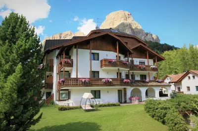 a large building with a mountain in the background at Pera Ciaslat in Colfosco