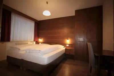a bedroom with a bed and a table and a desk at Pera Ciaslat in Colfosco