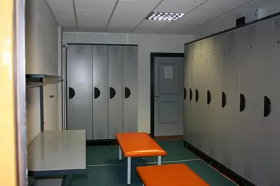a locker room with an orange bench and lockers at Pera Ciaslat in Colfosco