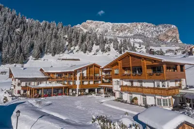 a ski lodge in the mountains in the snow at Hotel Welponer in Selva di Val Gardena