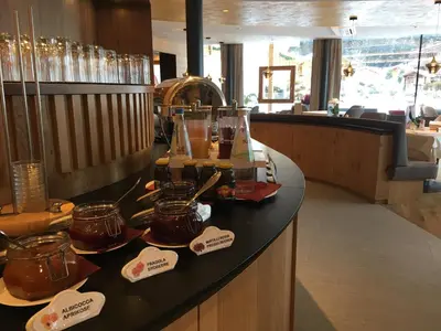 a restaurant with a counter with jars of honey at Hotel Welponer in Selva di Val Gardena