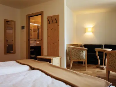 a hotel room with a bed and a table and chairs at Garni Le Maddalene in Coredo