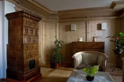 a room with a fireplace and a table and chair at Garni Le Maddalene in Coredo