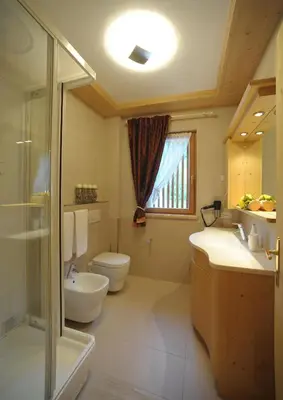 a bathroom with a toilet and a sink and a shower at Romantic Chalet Dolomiti in Val di Zoldo