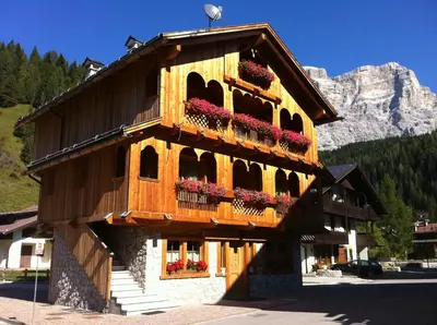 a building with flower boxes on the side of it at Romantic Chalet Dolomiti in Val di Zoldo