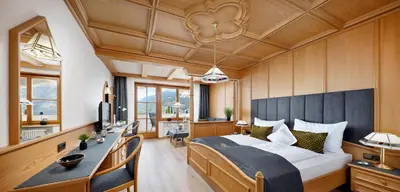 a bedroom with a large bed and a desk at Panorama Vital Hotel Rimmele in Tirolo