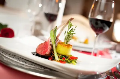 a plate of food on a table with a glass of wine at Panorama Vital Hotel Rimmele in Tirolo