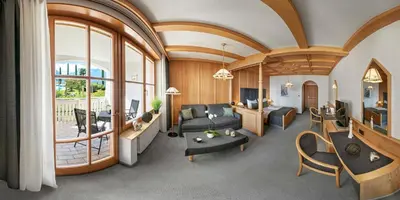 a living room filled with furniture and a large window at Panorama Vital Hotel Rimmele in Tirolo