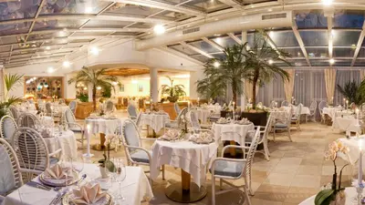 a banquet hall with white tables and chairs at Panorama Vital Hotel Rimmele in Tirolo