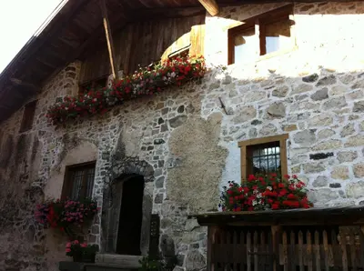 a building with flowers on the side of it at Rustico nelle Dolomiti in Val di Zoldo