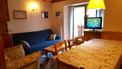 a living room with a blue couch and a table at Rustico nelle Dolomiti in Val di Zoldo