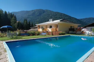 a swimming pool in the middle of a yard at Hotel Central in Nova Levante