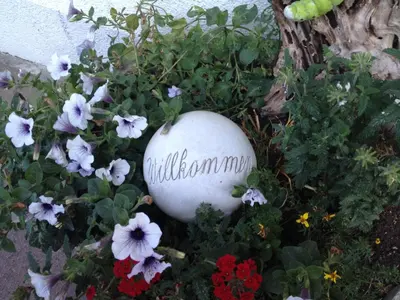 a rock sitting in a garden of flowers at Zehrehof in Bressanone
