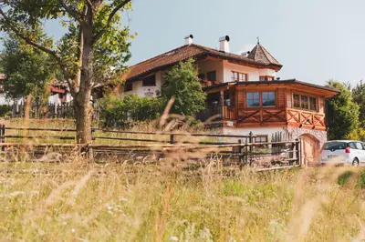 a house with a car parked in front of it at Agriturismo Maso Corradini in Castello di Fiemme