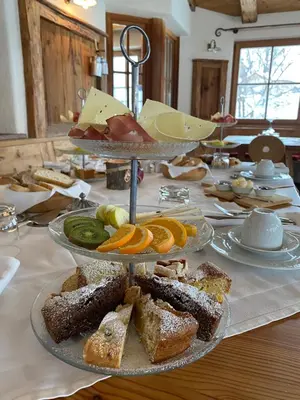 a table with several plates of food on a table at Agriturismo Maso Corradini in Castello di Fiemme