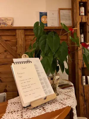 a table with a book and a plant on it at Agriturismo Maso Corradini in Castello di Fiemme