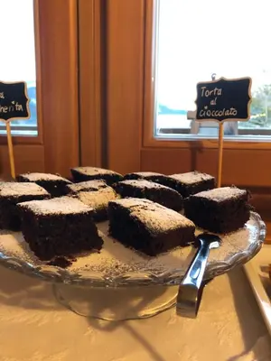 a plate of chocolate cakes on a table with signs at Agriturismo Maso Corradini in Castello di Fiemme