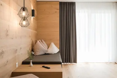 a room with a bed with pillows and a window at Park Hotel Villa Etschland in Plaus