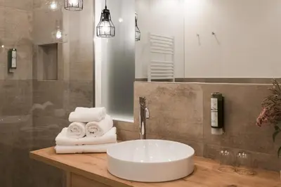 a bathroom with a sink with towels on a counter at Park Hotel Villa Etschland in Plaus