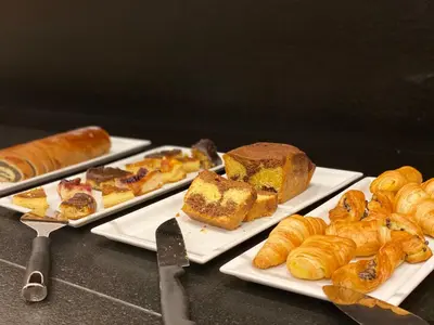 a table with three plates of pastries and croissants at Park Hotel Villa Etschland in Plaus