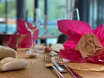 a table with a pink flower on top of it at Park Hotel Villa Etschland in Plaus