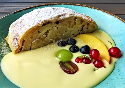 a piece of cake on a blue plate with fruit at Reiterhof Edelweiss in San Genesio Atesino