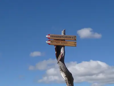 a wooden sign with arrows on top at Reiterhof Edelweiss in San Genesio Atesino