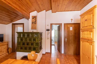 a living room with a green cabinet and a wooden ceiling at Chalet Catinaccio in Soraga