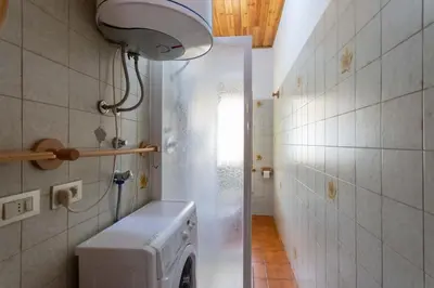 a laundry room with a washing machine and a light at Chalet Catinaccio in Soraga