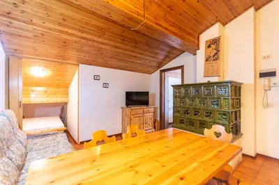 a living room with a wooden floor and a wooden table at Chalet Catinaccio in Soraga