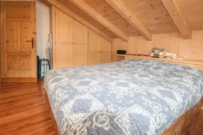 a bedroom with a bed in a wooden room at Tabià Elisa in Campitello di Fassa