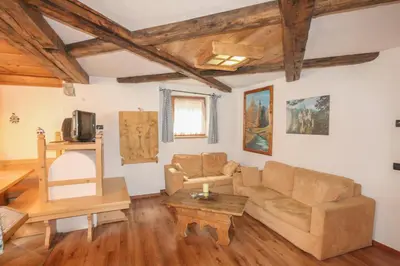 a living room with a couch and a table at Tabià Elisa in Campitello di Fassa