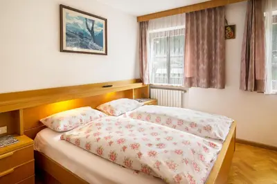 a bedroom with two beds and a window at Casa Matie in Selva di Val Gardena