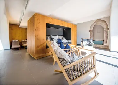 a bedroom with a large bed with a wooden wall at Hotel Kabis in Funes