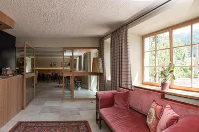 a living room with a red couch and windows at Hotel Kabis in Funes