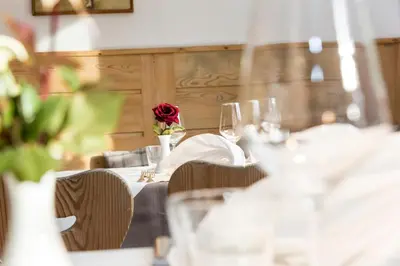 a table with wine glasses and a rose on it at Hotel Kabis in Funes
