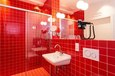 a red tiled bathroom with a sink and a mirror at Hotel Kabis in Funes
