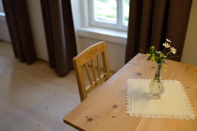 a wooden table with a vase with flowers in it at Hotel Kabis in Funes
