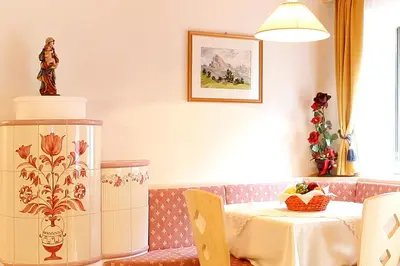 a dining room with a table and a table and chairs at Garni B&B Schenk in Selva di Val Gardena