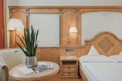 a bedroom with a bed and a table with a potted plant at Hotel Sonklarhof in Ridanna