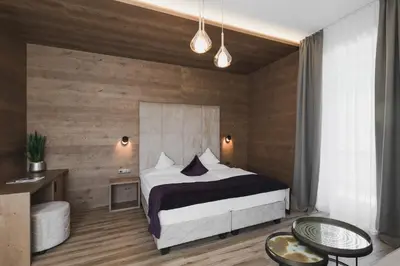 a bedroom with a bed and a wooden wall at Hotel Sonklarhof in Ridanna