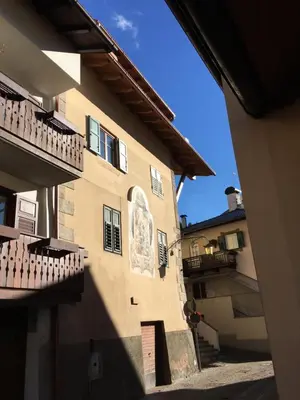 a building with a mural on the side of it at Mountain Dolomiti Apartments-Maison Perrod in Predazzo