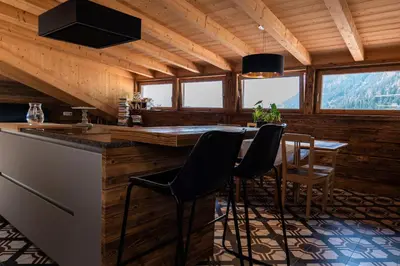 a kitchen with a table and chairs in a cabin at Mountain Dolomiti Apartments-Maison Perrod in Predazzo