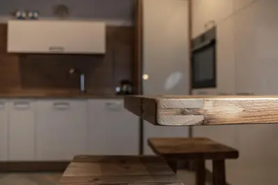 a kitchen with white cabinets and a wooden counter top at Mountain Dolomiti Apartments-Maison Perrod in Predazzo