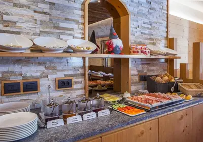 a buffet with many different types of food on a counter at Garni Lanzinger in Selva di Val Gardena