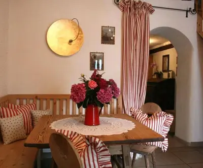 a dining room table with a vase of flowers on it at Residence Streitlhof in Tirolo