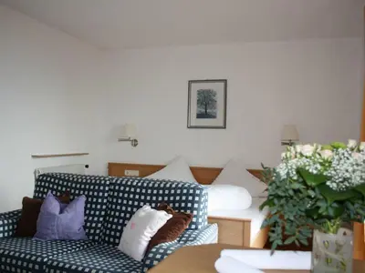 a living room with a blue and white couch with pillows at Residence Streitlhof in Tirolo