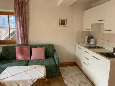 a living room with a green couch in a kitchen at Residence Streitlhof in Tirolo